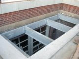 Structural galvanized beam grating supports with grouted wall pockets, epoxy, masonry anchors, and welded galvanized steel angle clip connections. (Institutional facility – Queens, NY)