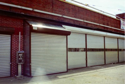 Solid manual roll down security gates with 12" grilles insert and steel filler panels for built out vending area. (Brooklyn NY) 1 of 2
