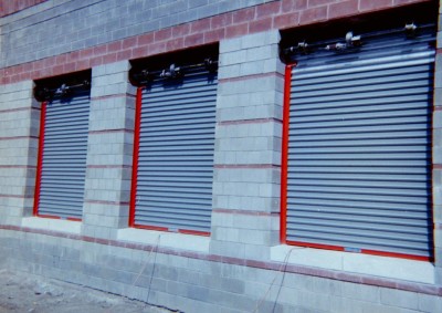 Solid roll down gates with internal motors and custom colored guides and frame. Jam to jam mount. (Manhattan, NY)