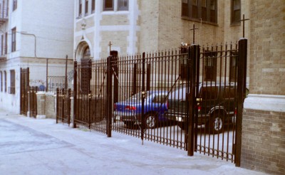 Fully welded 8' tall solid ¾" square bar fence with cross braces, circles and arrows on top. Mounted to ¼" thick 4" square tube posts buried in 36" deep core drilled cement footings. Driveway gates with locks and 4' walkway gates. Primed and painted. (Bronx, NY)