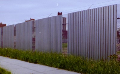 Expanded metal and corrugated steel deck combo 10’ fence with barded wire. (Queens, NY)