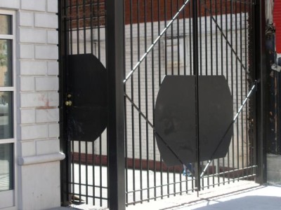8' Tall welded 5/8" solid square bar fence with structural posts, cross bracing to heavy welded hinges, custom steel plates and steel rod floor cane on door and driveway gates. (Brooklyn, NY)