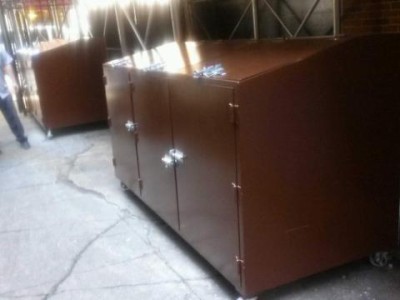 Custom steel garbage pale bins with lockable slidebolts top and front on 5 inch wheels,painted brown.