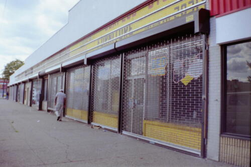 Entire Strip mall of new grille type see through chain operated roll down gate in Brick Pattern (Queens NY) After Photo